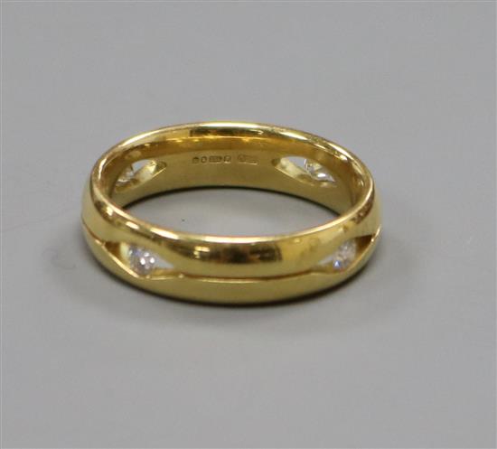 A modern pierced 18ct gold band, set with four gypsy set diamonds, size N.